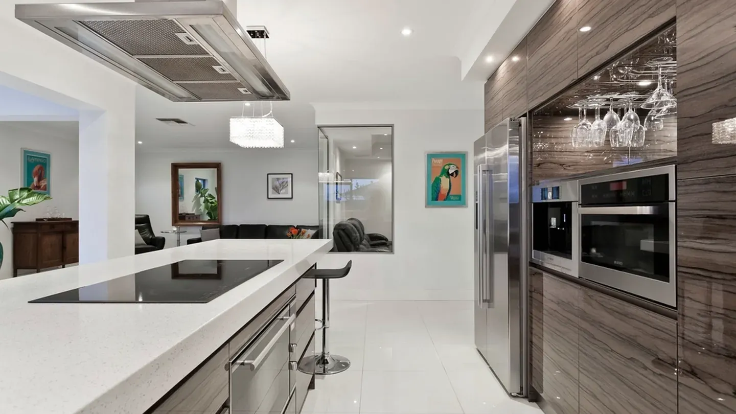 Two-tone contemporary kitchen with a white island and a dark wood tall run