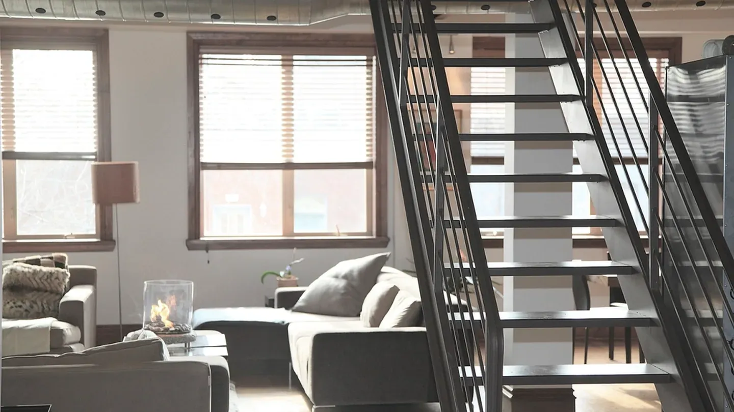 Industrial loft interior with a blackened steel stair and structure left exposed